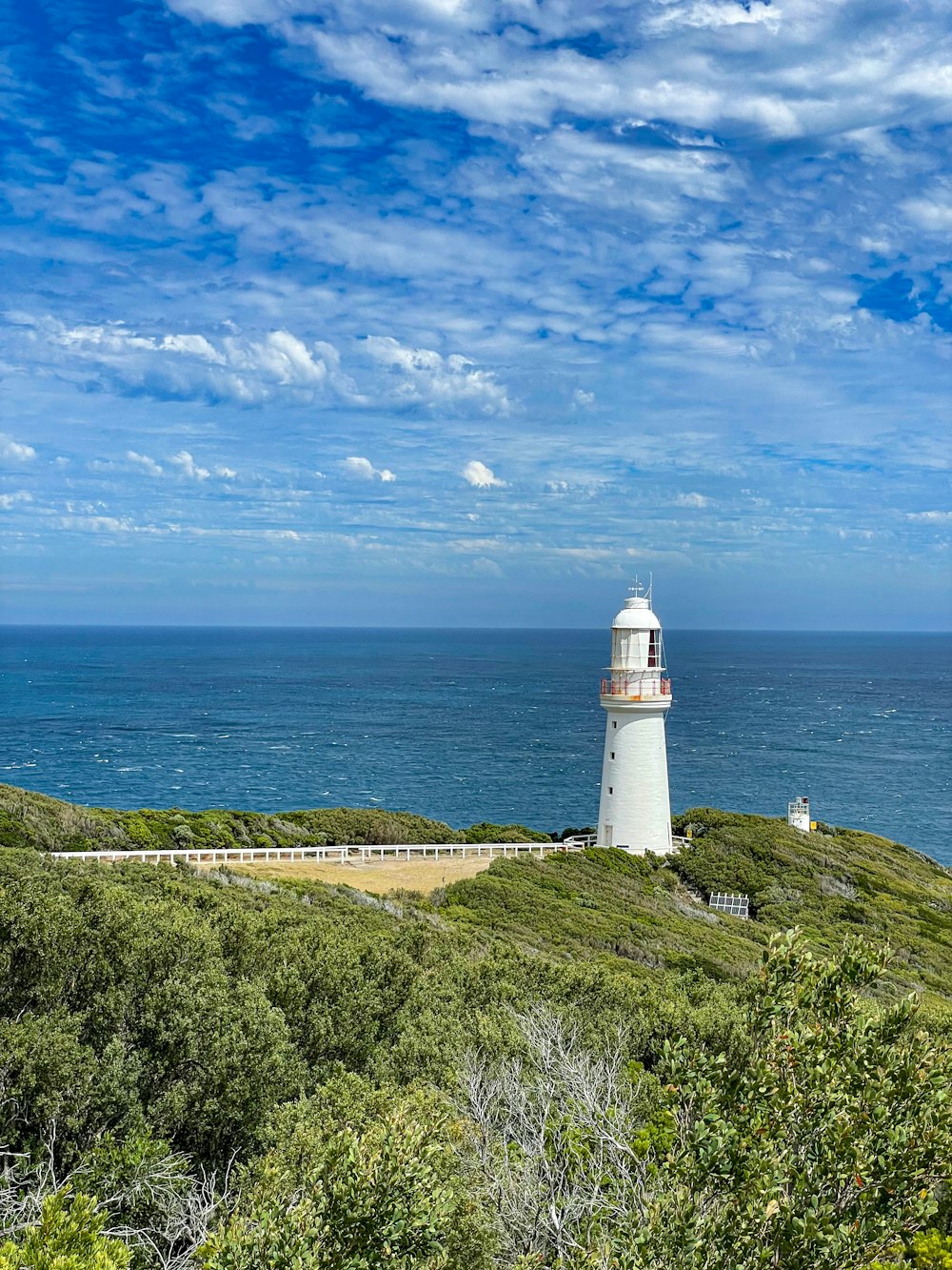 a lighthouse on a hill overlooking the ocean