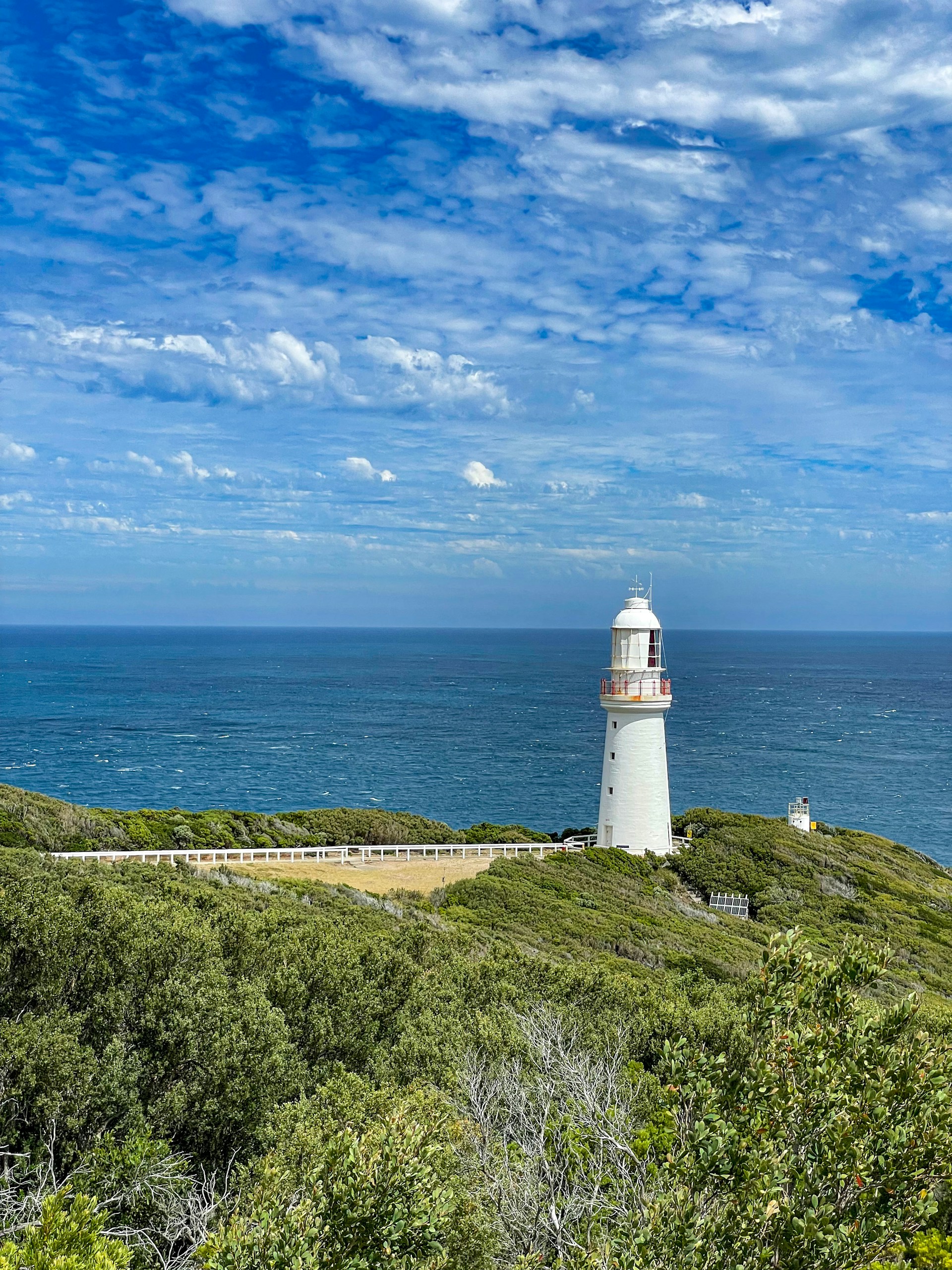 a lighthouse on a hill overlooking the ocean