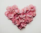 a heart made of pink flowers on a white background