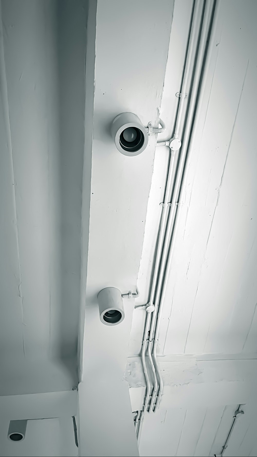 two security cameras mounted to the side of a wall