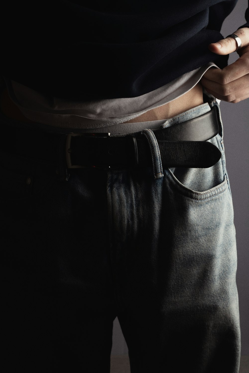 a man is wearing a belt and jeans