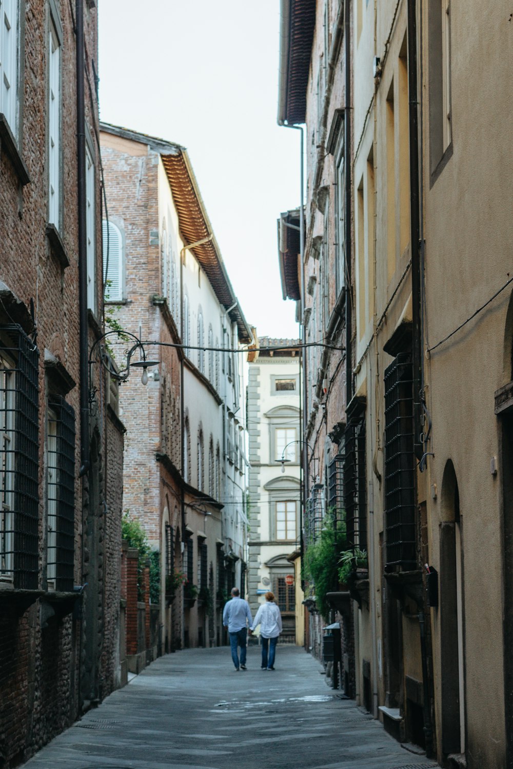 Dos personas caminando por un callejón estrecho