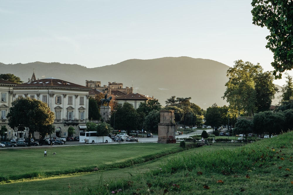 a large building with a clock tower in the middle of a park