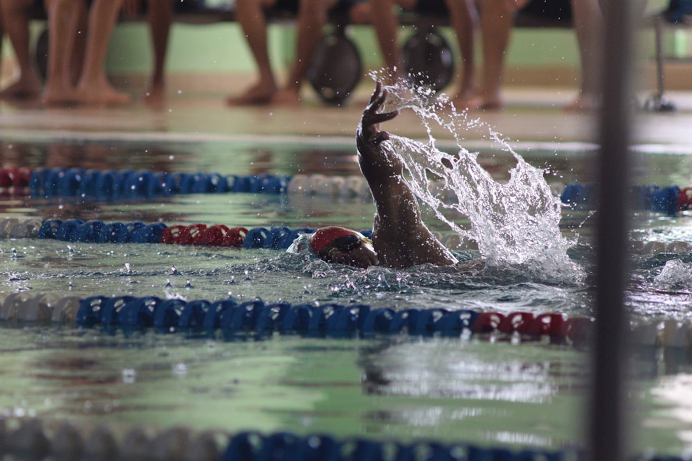 a man swimming in a pool surrounded by people