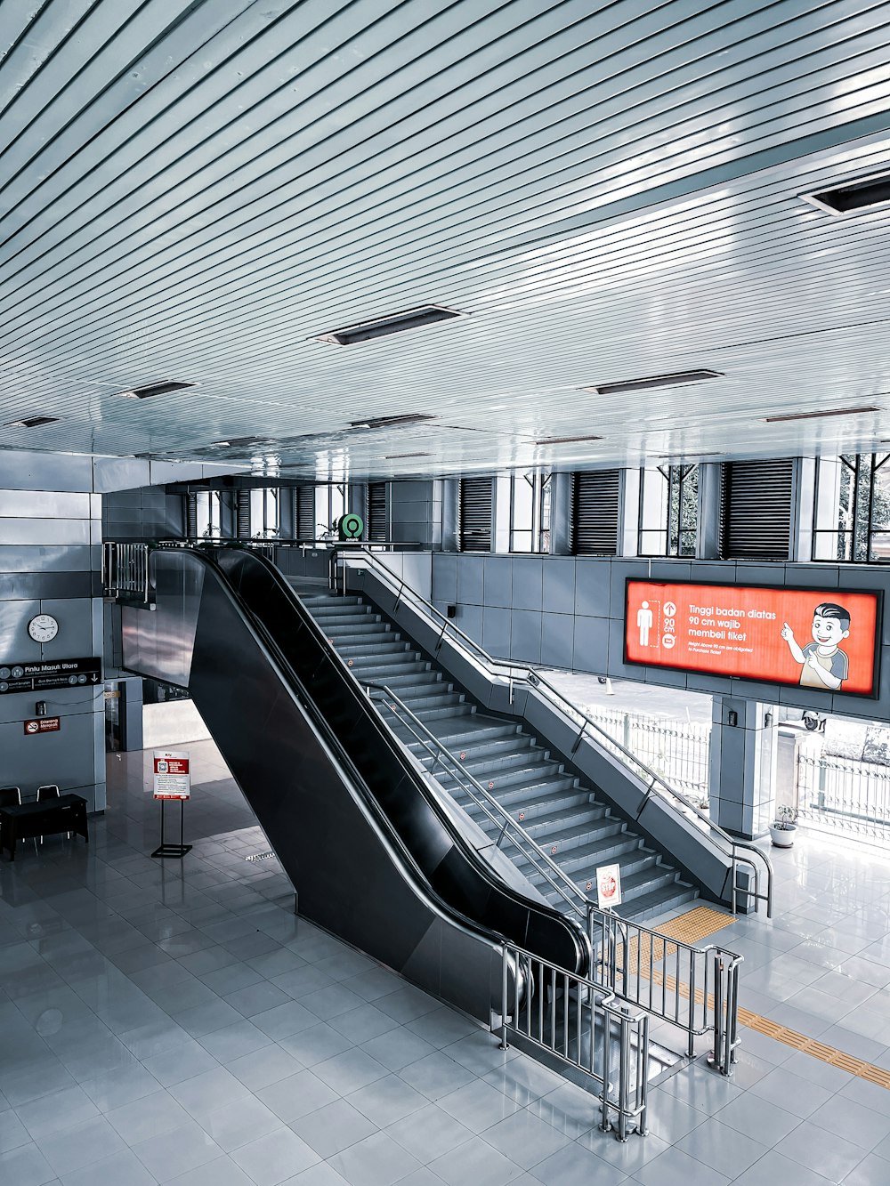 an escalator in a subway station with a sign on the wall