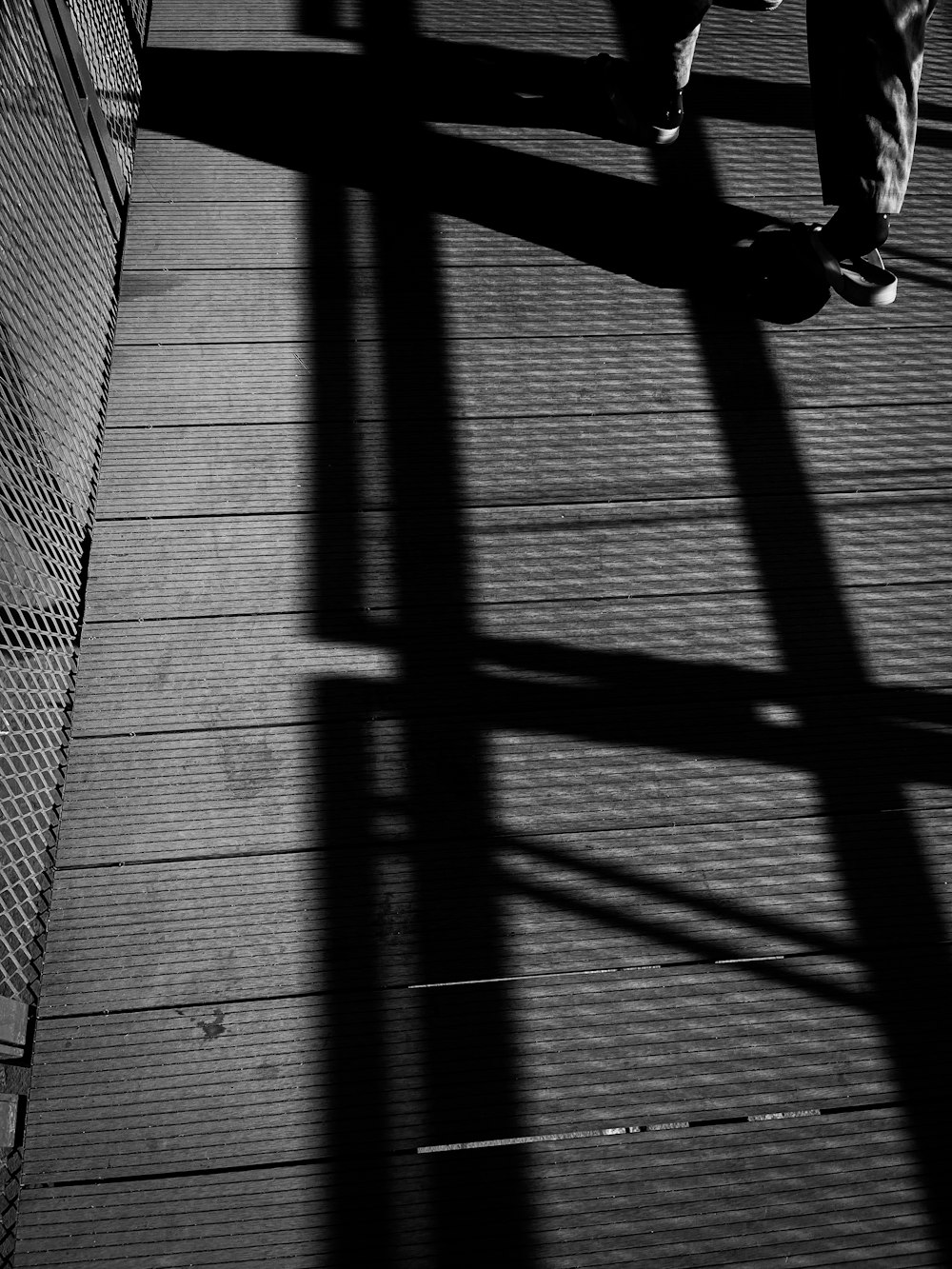 a person walking across a bridge with a skateboard