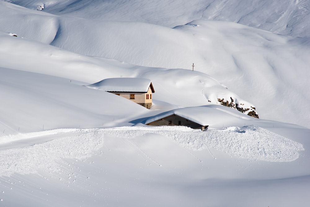 a snow covered hill with a house on top of it