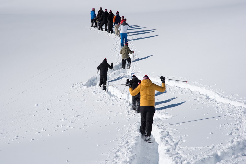 a group of people walking up a snow covered slope