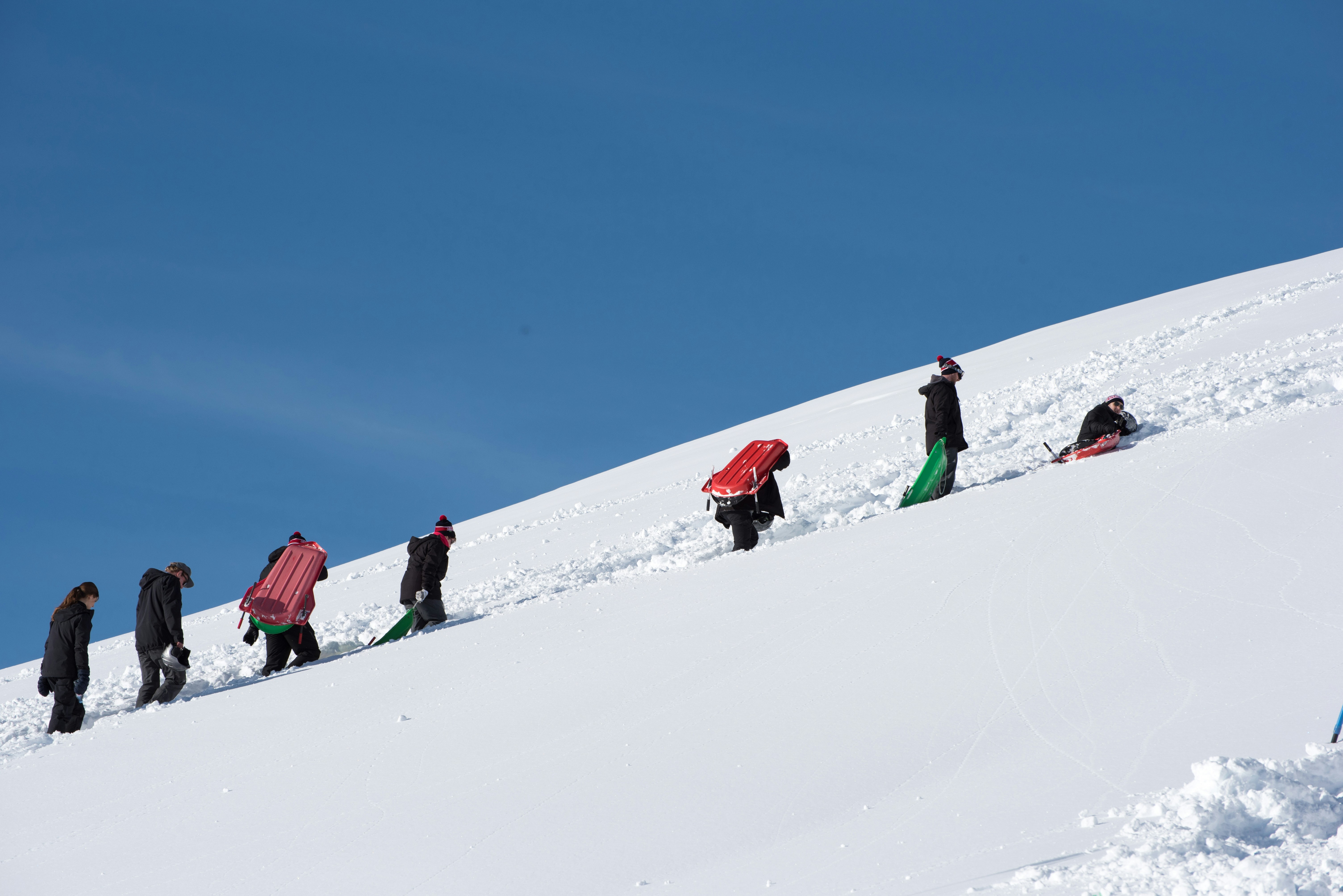 un groupe de personnes marchant sur une colline enneigée