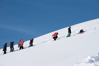 a group of people walking up a snow covered hill