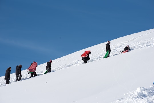 a group of people walking up a snow covered hill