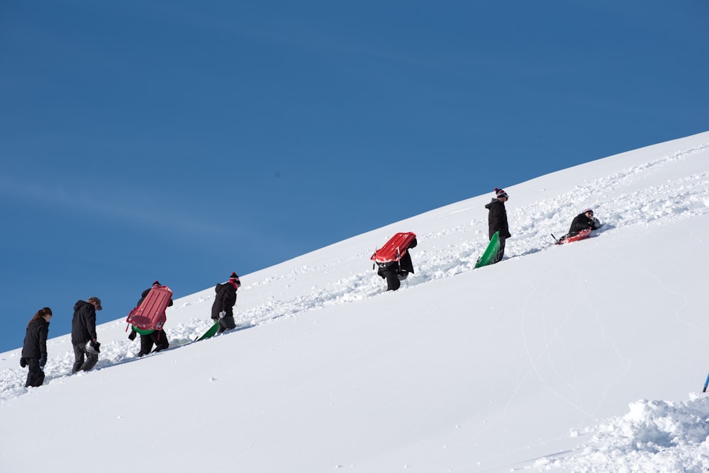 a group of people walking up a snow covered hill