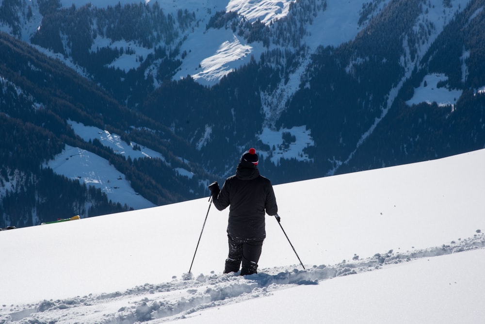 a person riding skis on top of a snow covered slope