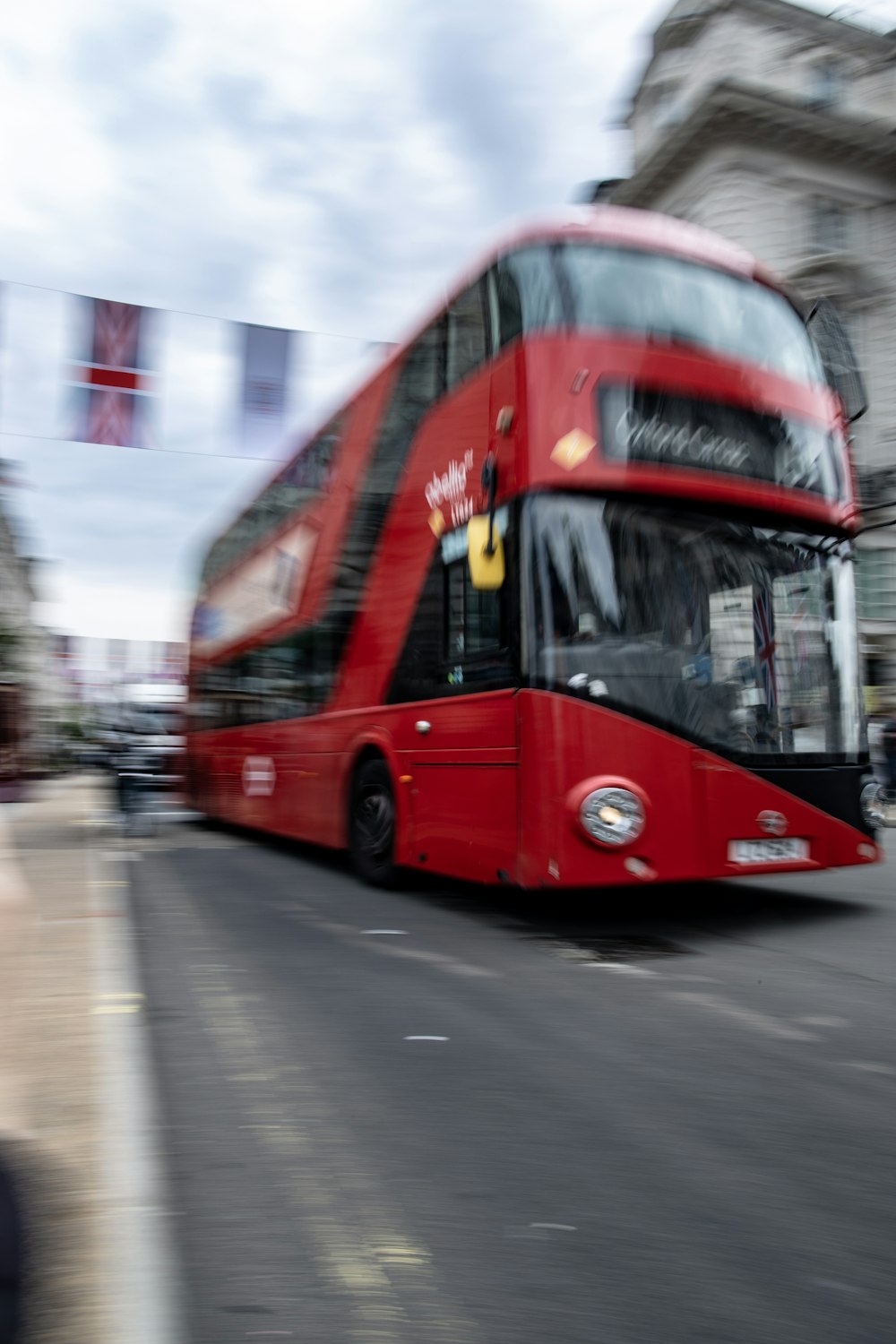 a red double decker bus driving down a street