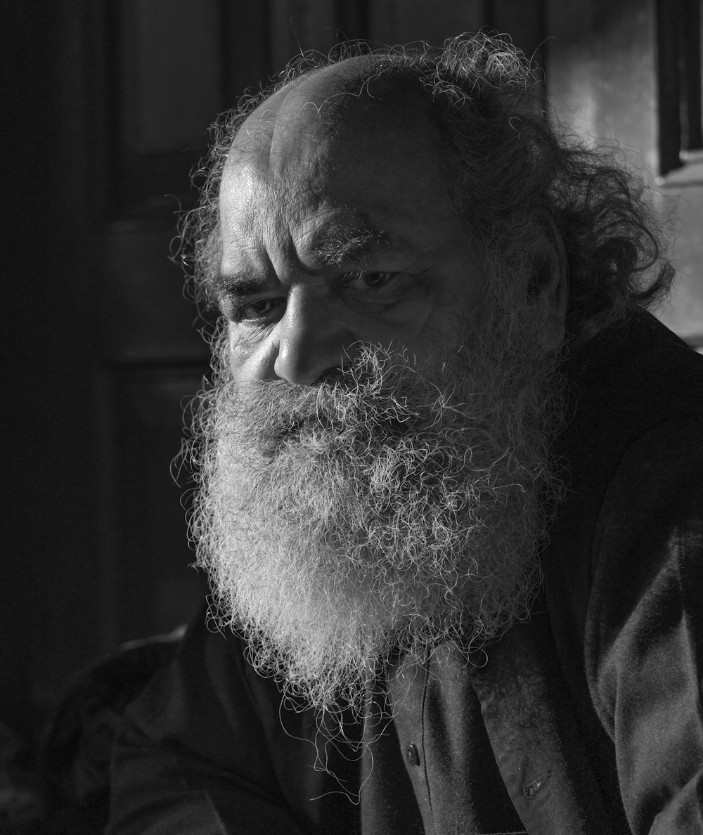 a black and white photo of a man with a long beard