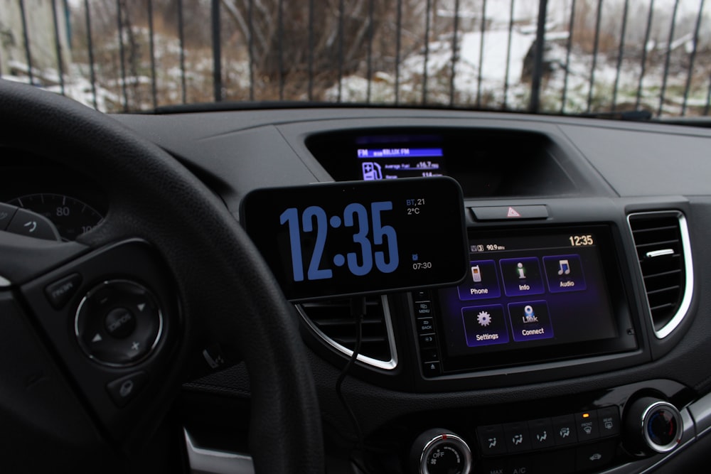 a car dashboard with a digital clock on it