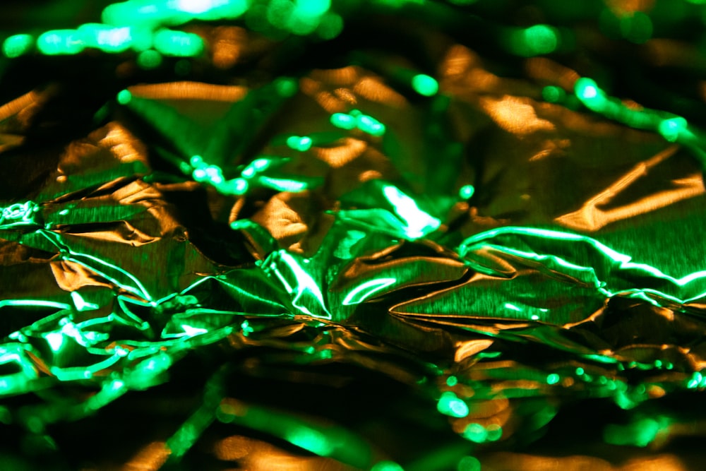 a bunch of shiny green leaves on top of a table