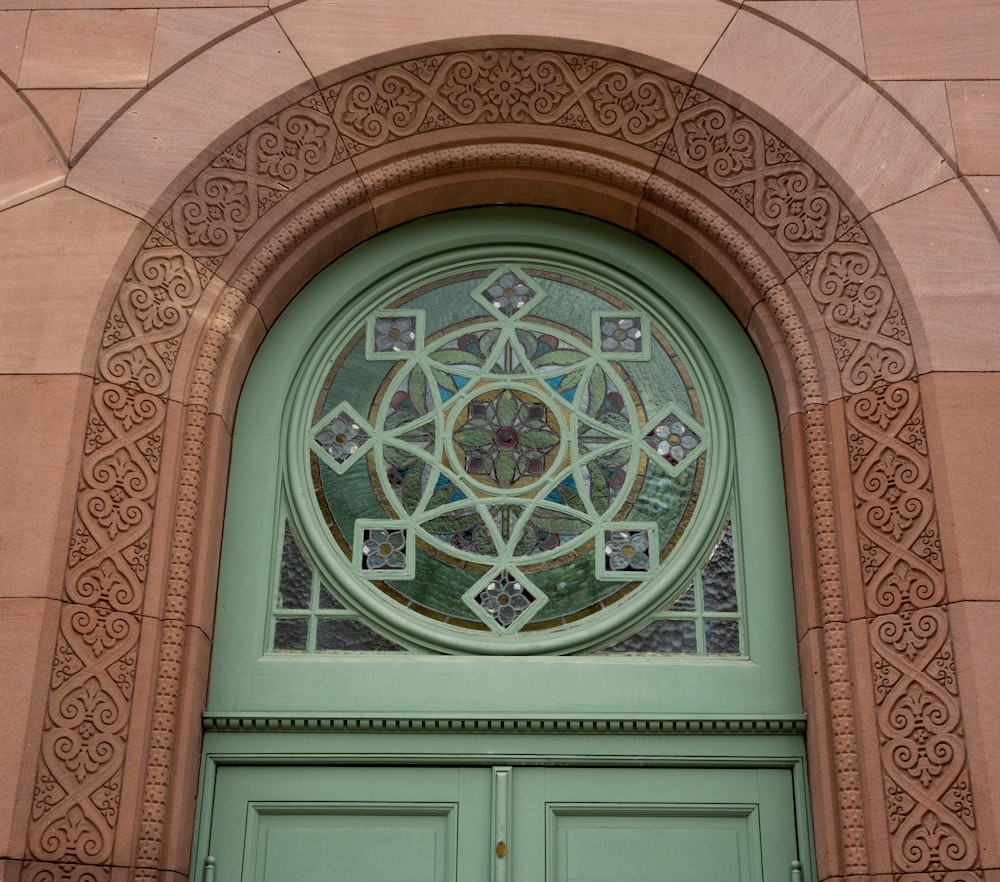 a green door with a stained glass window above it