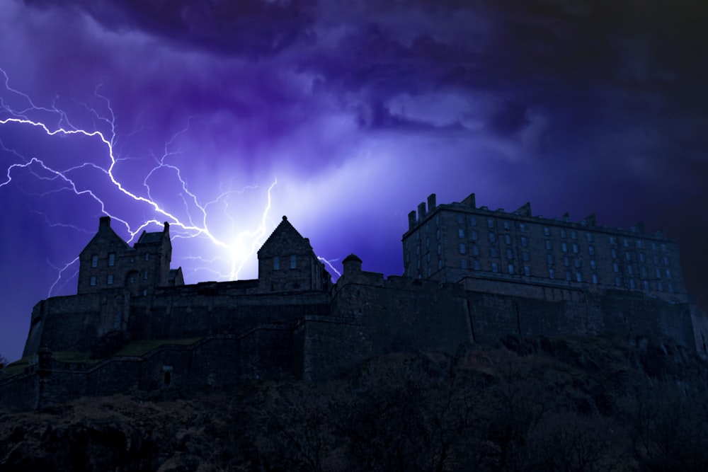 a lightning strikes behind a castle on a stormy night