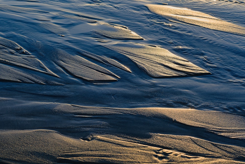 a close up of sand and water on a beach