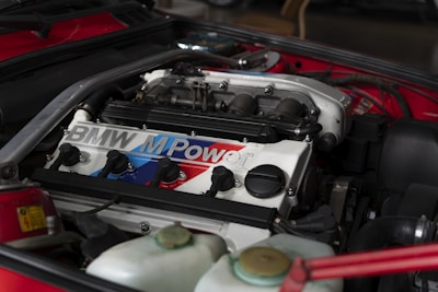 the engine compartment of a red sports car showing car battery sold in tyrepublic nigeria