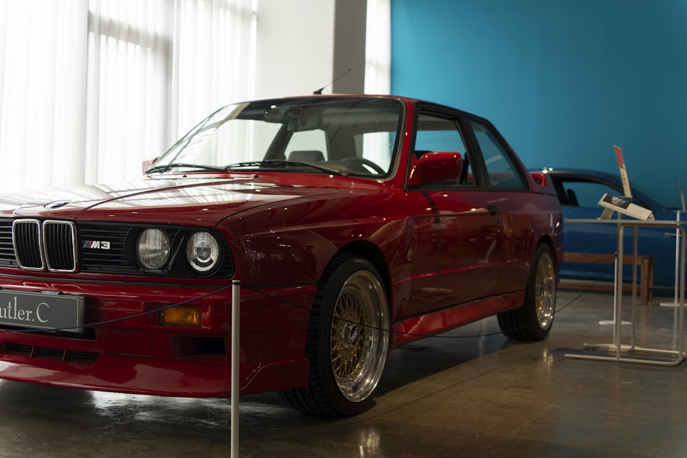 a red car is on display in a museum