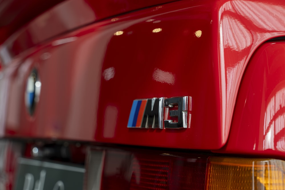a close up of a bmw emblem on a red car