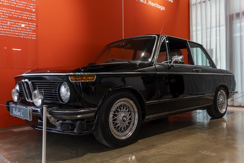 an old black car is on display in a museum