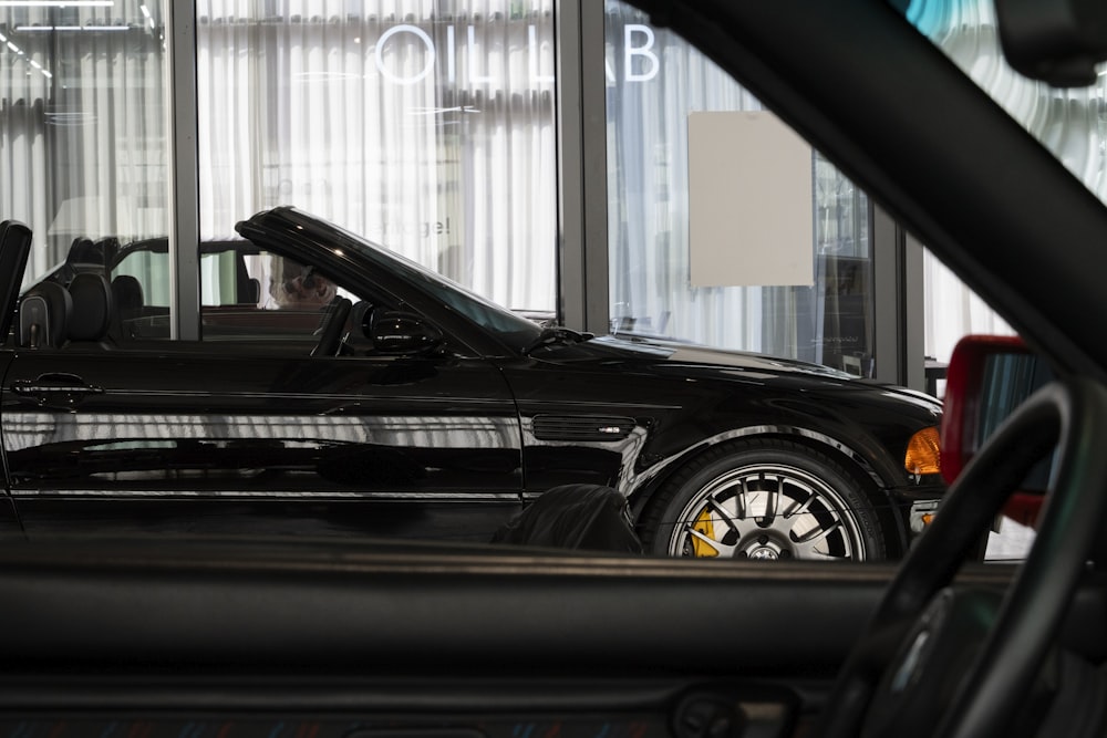 a black sports car parked in front of a building