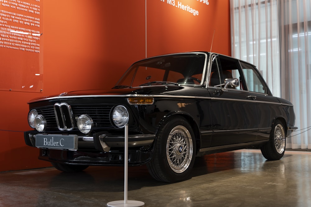 an old black car is on display in a museum