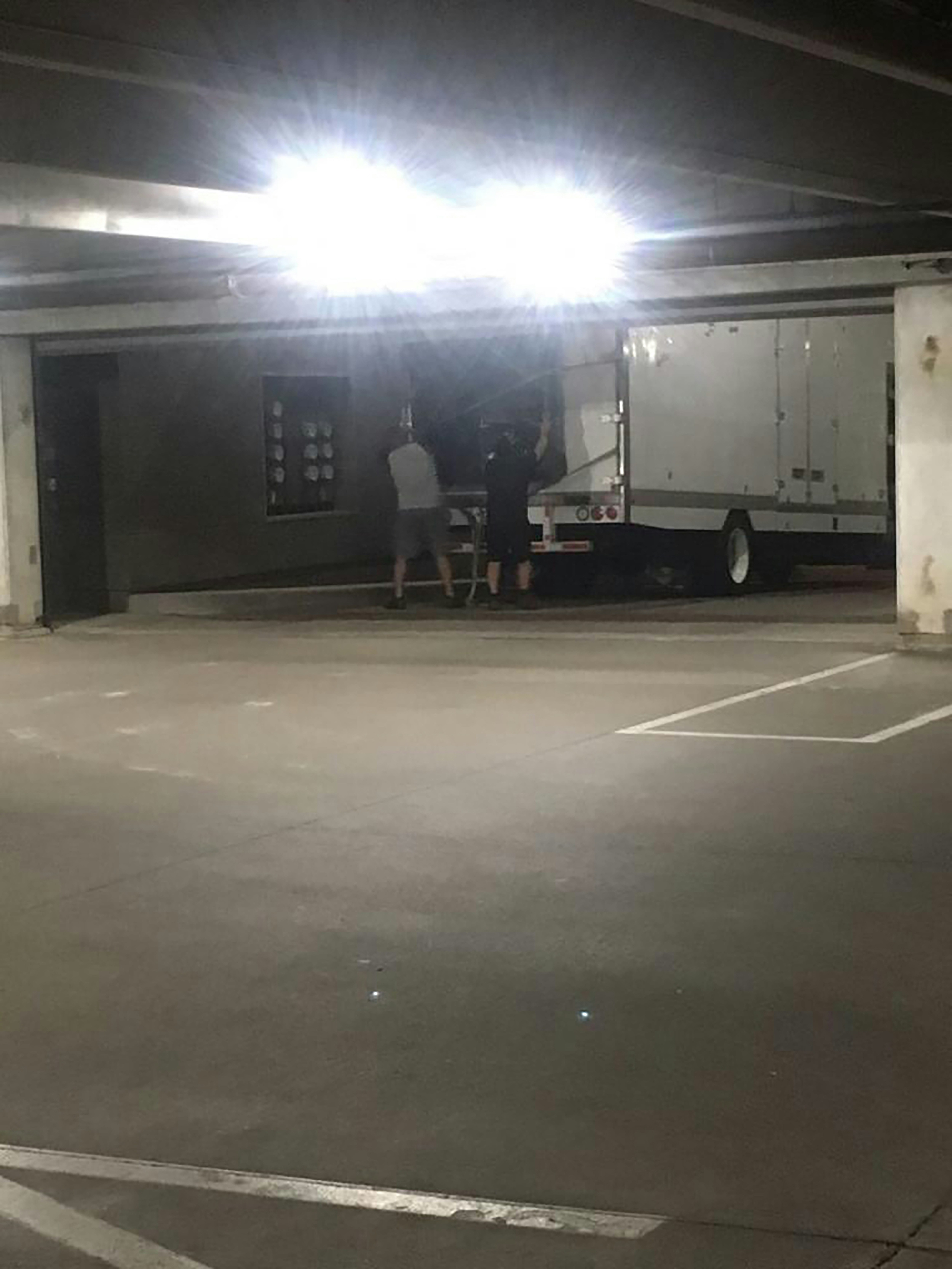 a man standing in a parking lot next to a truck