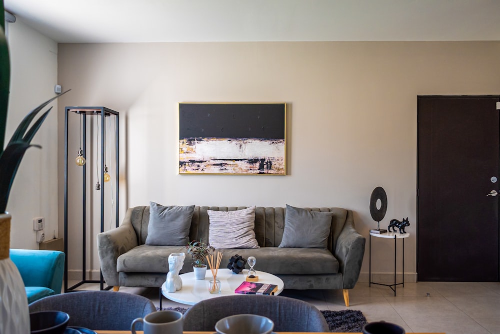 a living room filled with furniture and a painting on the wall