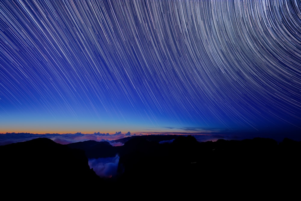 Uma trilha estelar é vista no céu acima das montanhas