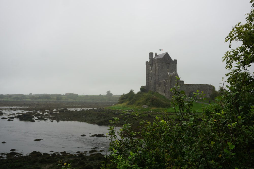 a castle sitting on top of a lush green hillside