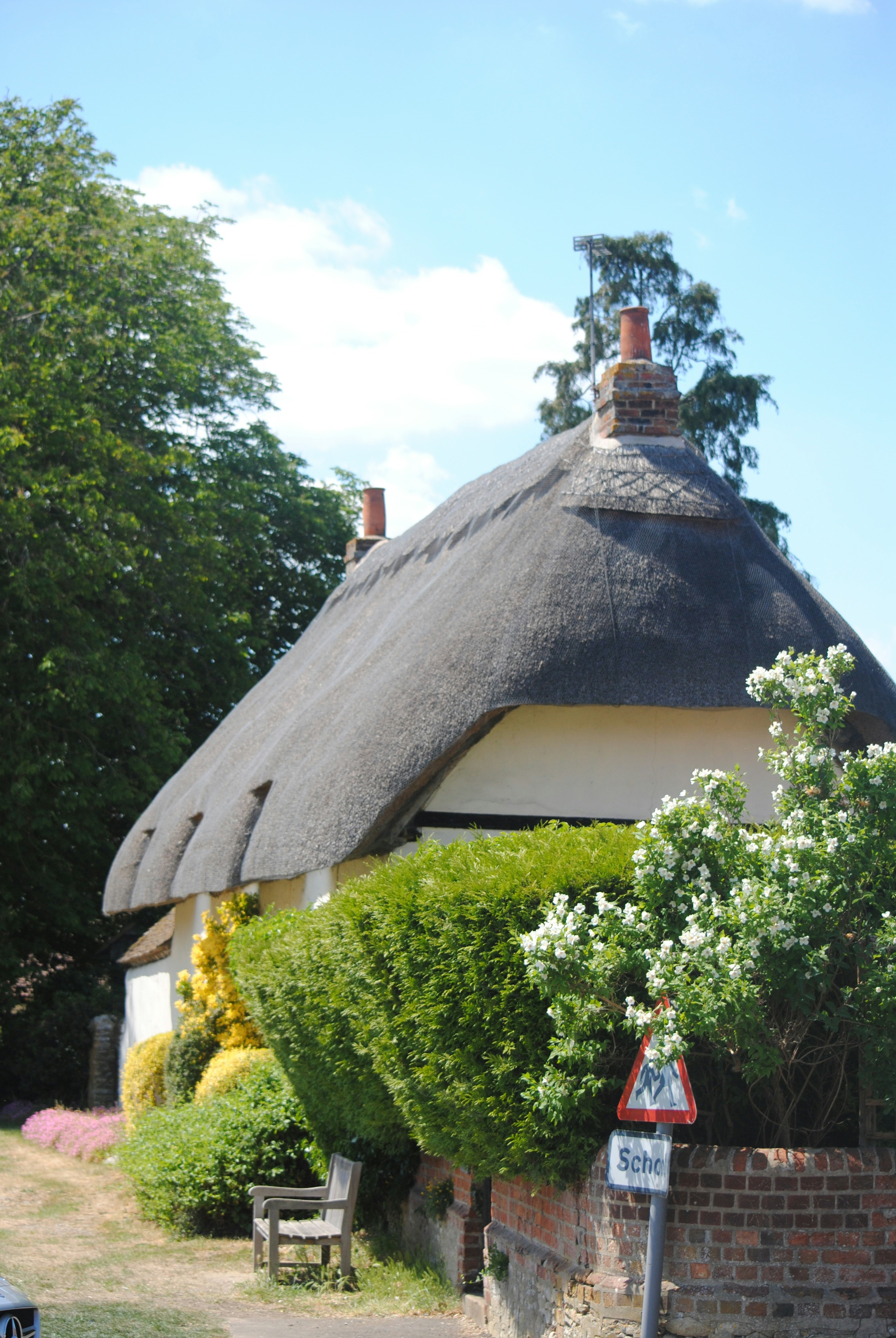 a house with a thatched roof and a bench