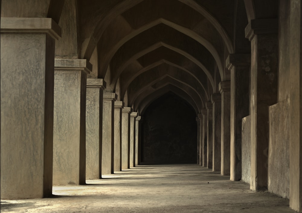 a long hallway with columns and a clock on the wall