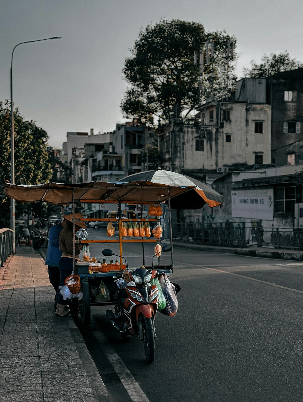 a man on a motorcycle with a cart full of items