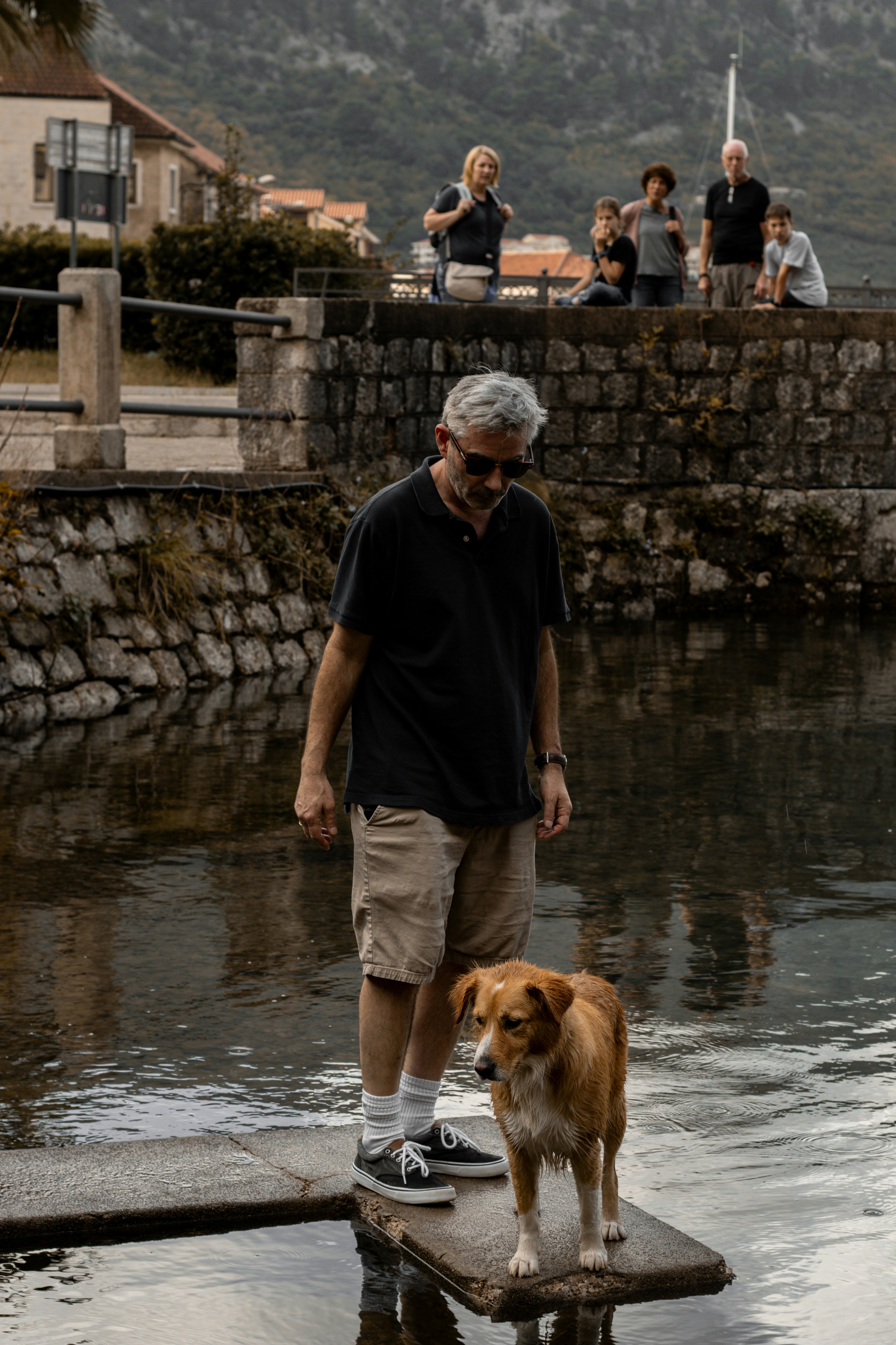 a man and his dog are standing on a dock