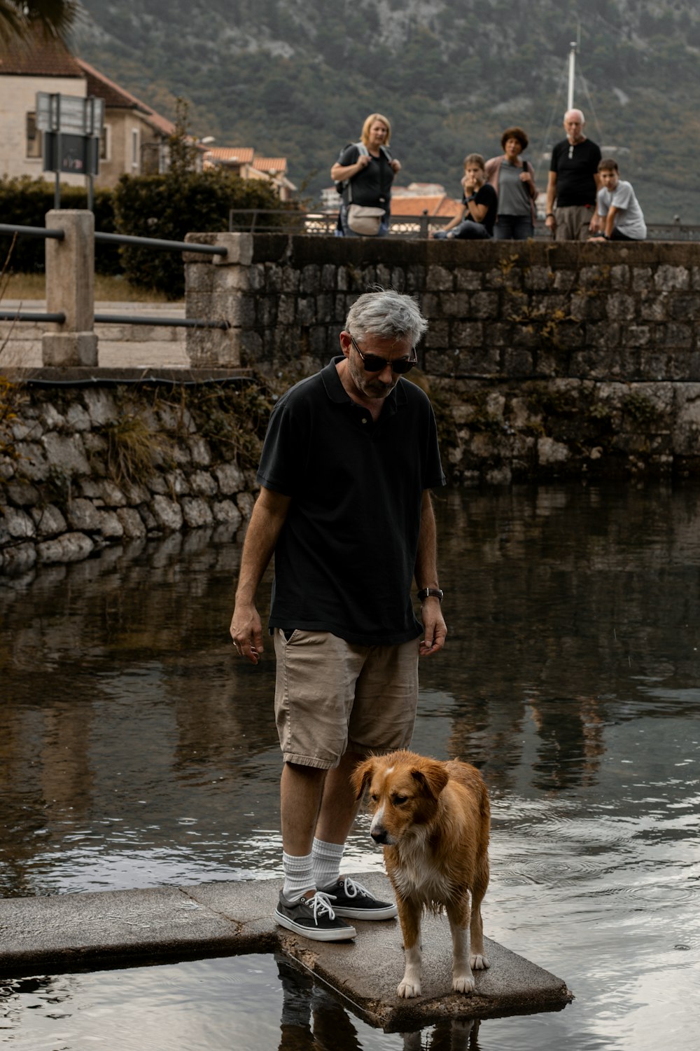 a man and his dog are standing on a dock