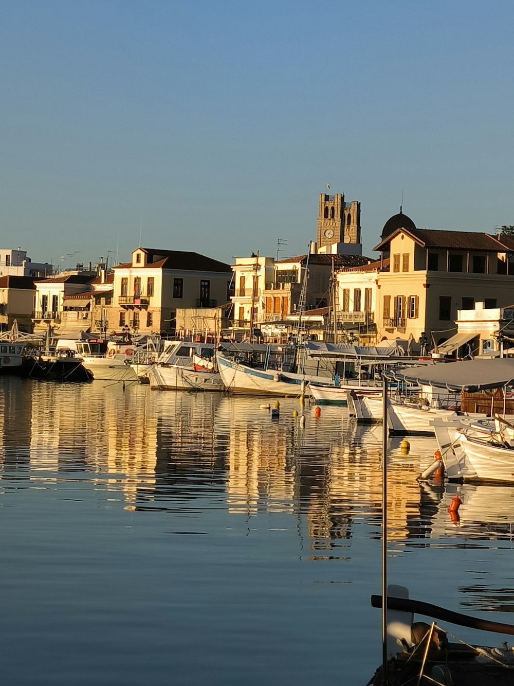 a harbor filled with lots of boats next to tall buildings