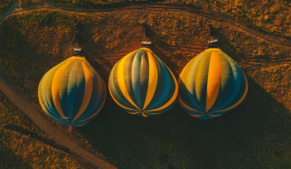 three hot air balloons sitting on top of a field