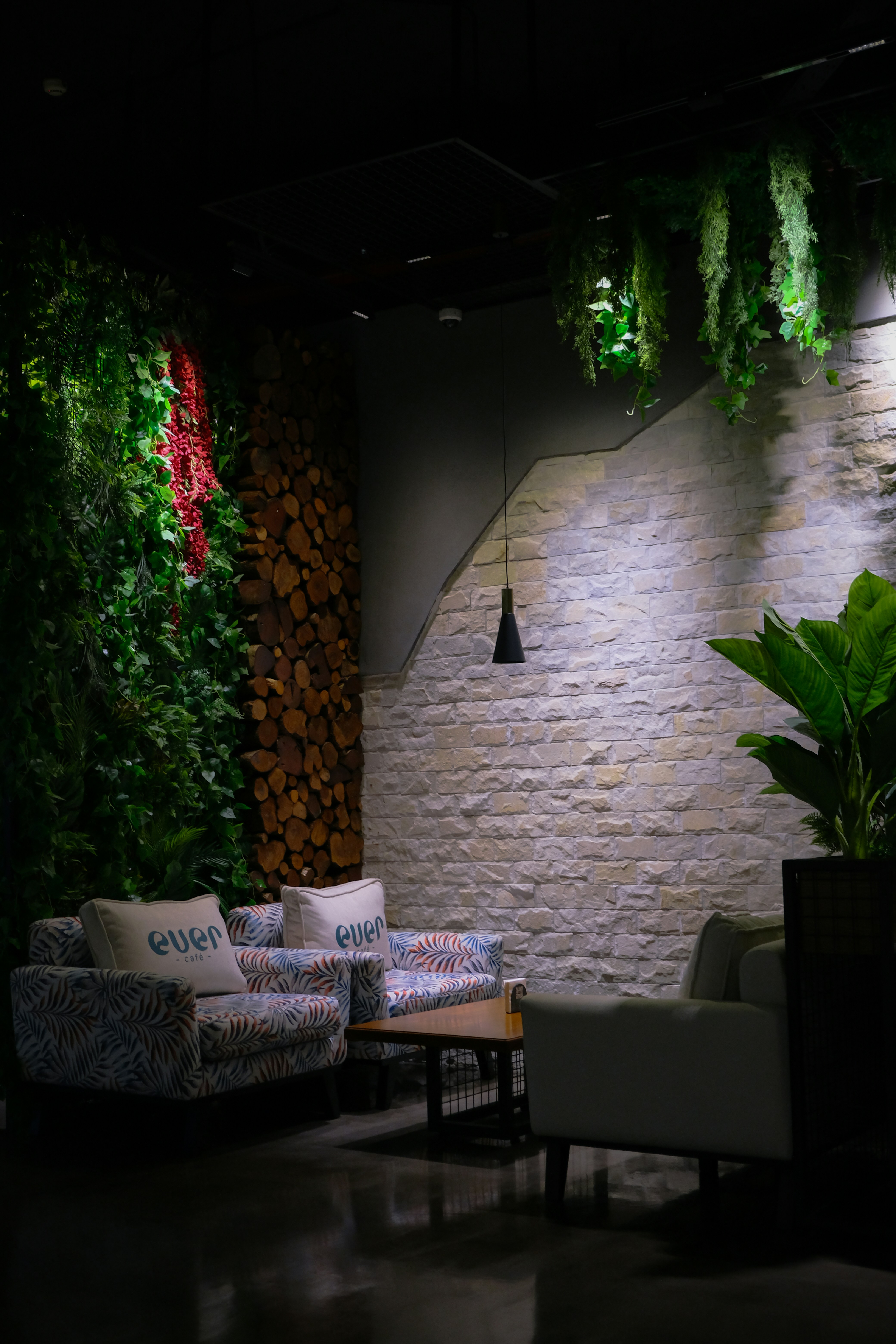 a living room with couches and plants on the wall