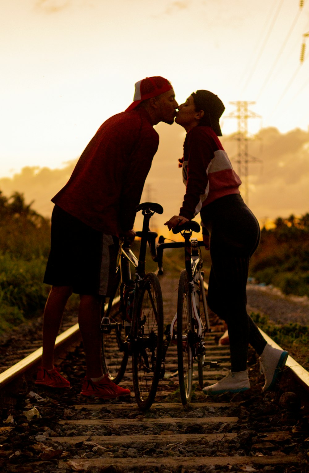 a man and a woman kissing on a train track