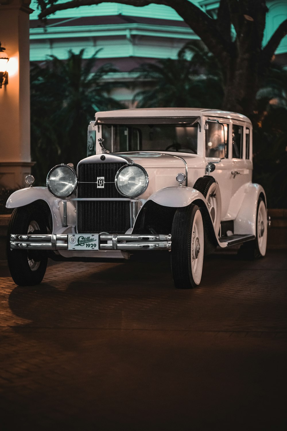 an old white car parked in front of a building