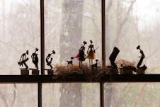 a group of figurines sitting on top of a window sill