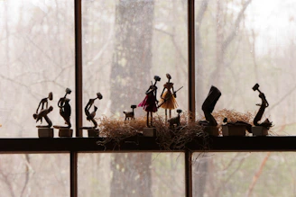a group of figurines sitting on top of a window sill