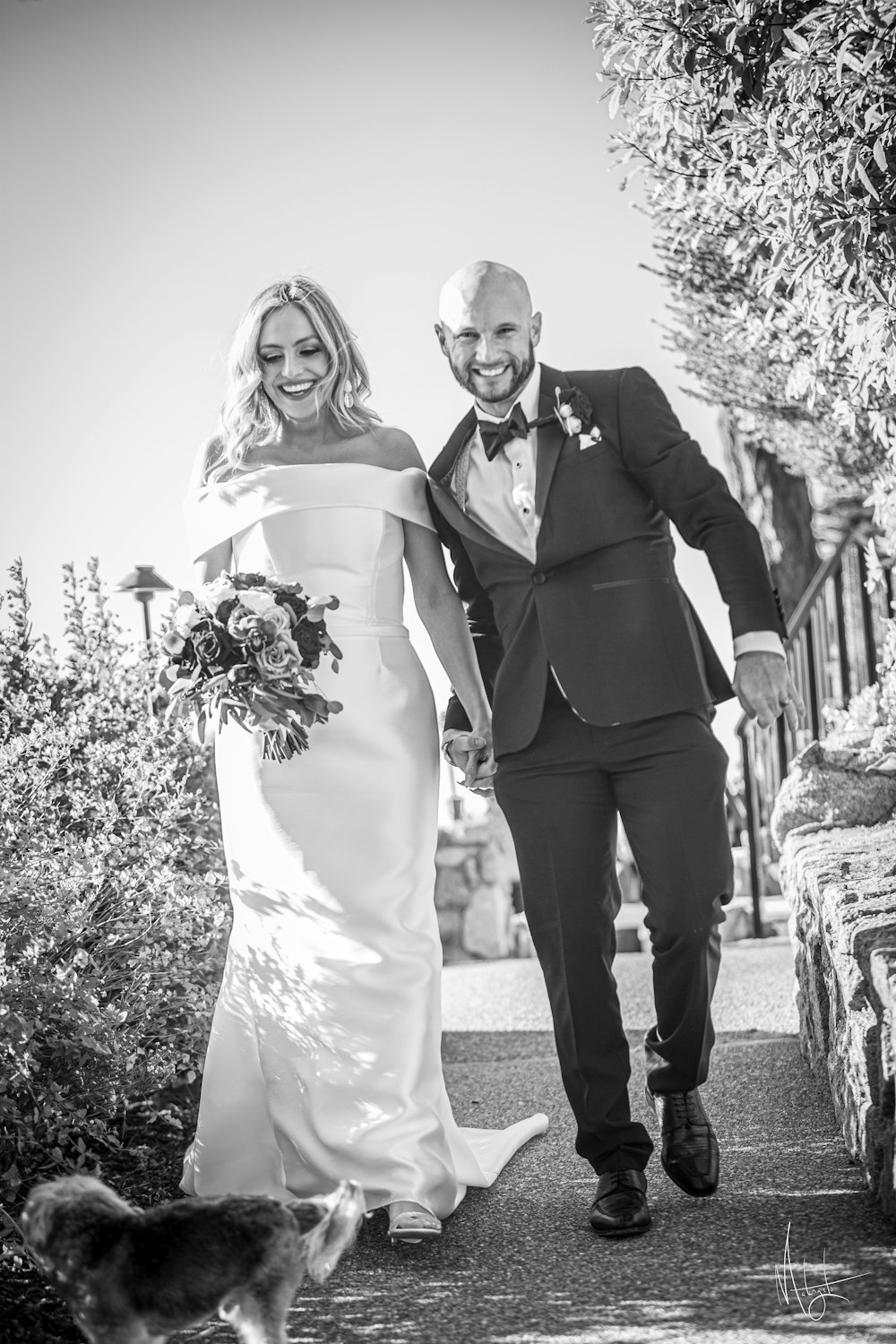 a bride and groom walking down a path