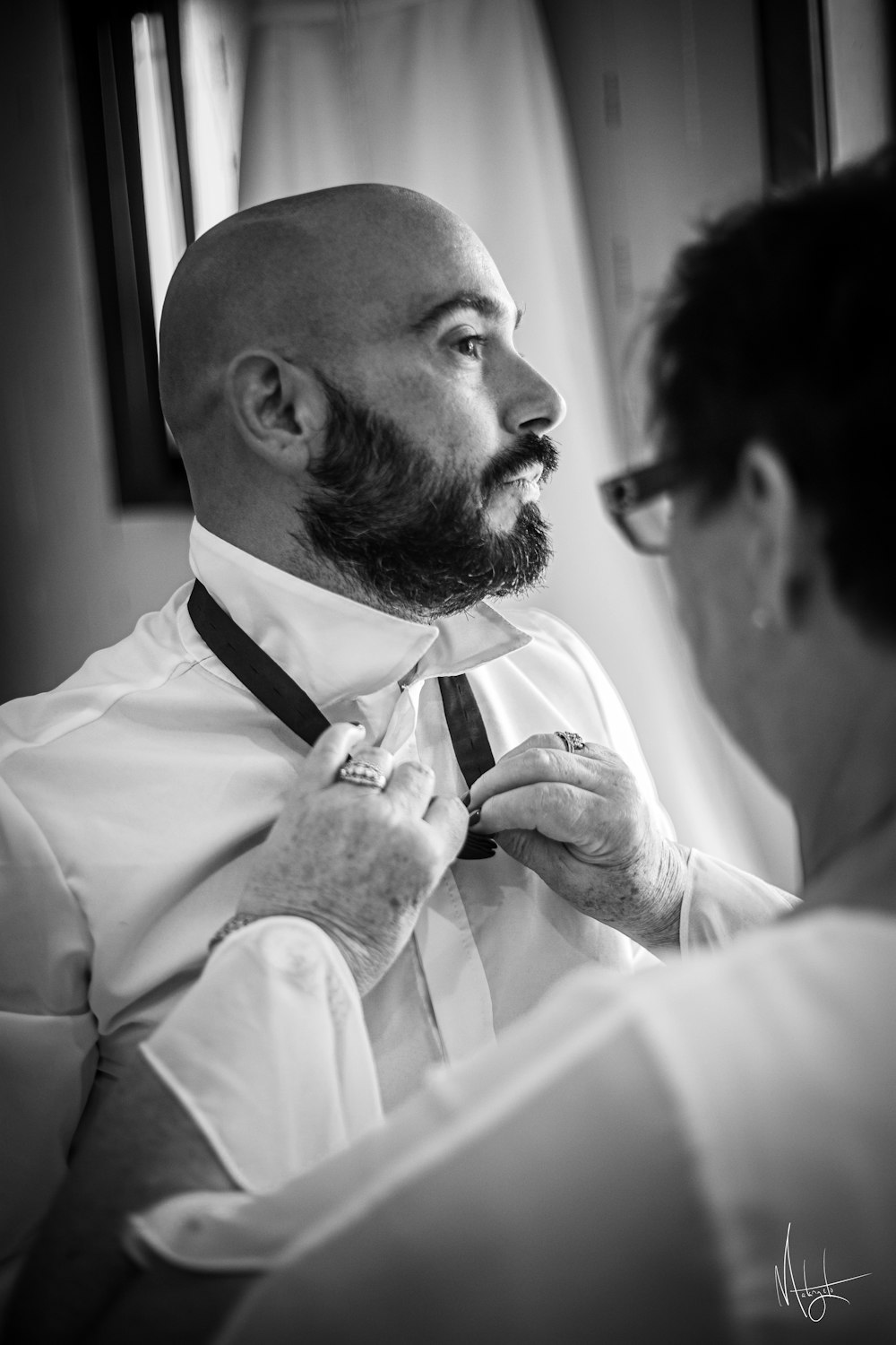 a man with a beard is fixing his tie