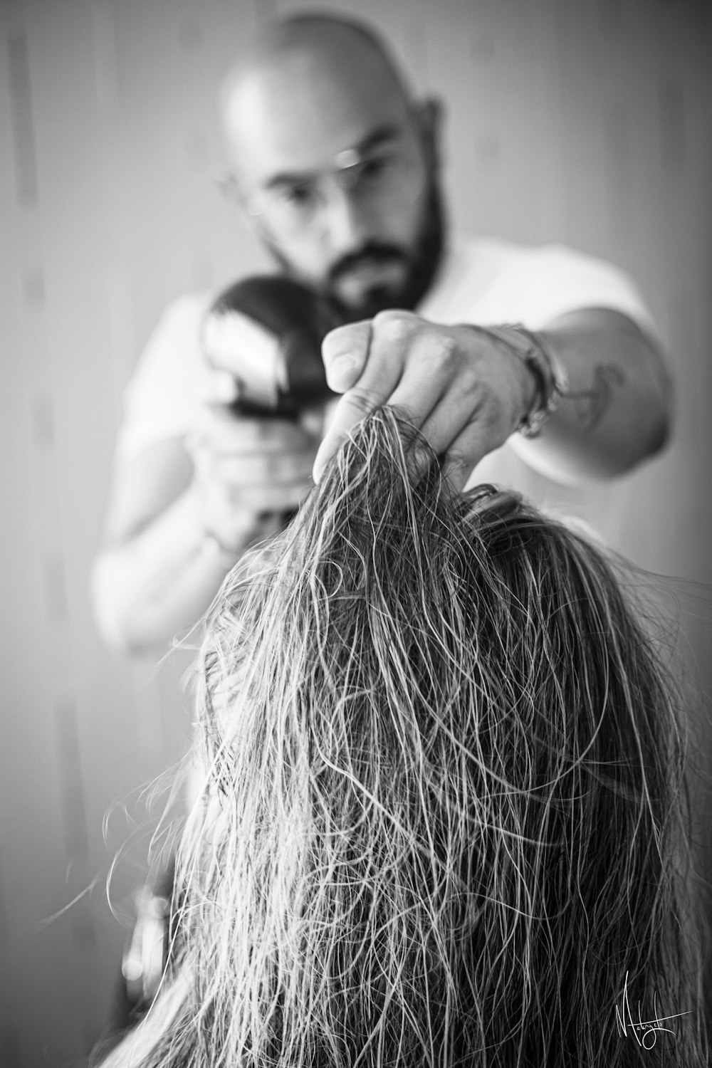 a man cutting another mans hair with a hair dryer