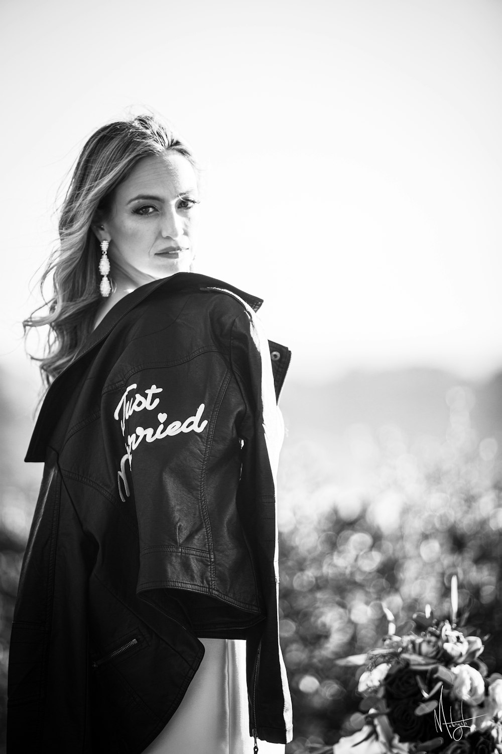 a woman standing next to a motorcycle wearing a leather jacket